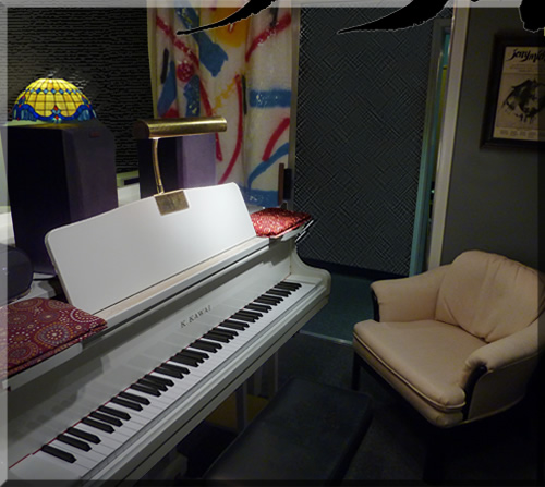 Photo of Jerry Michelsen piano studio with white grand piano, tiffany lamp, comfy white chair and nice atmosphere