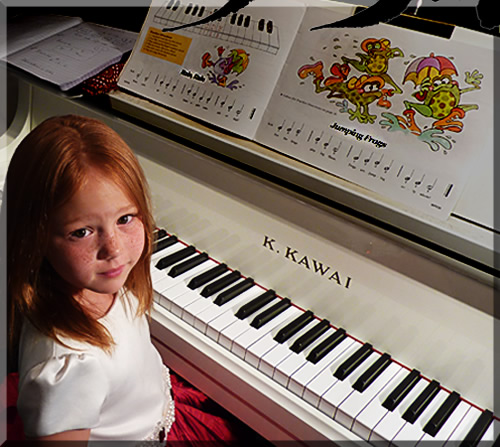 Photo of red haired five year old girl smiling at the piano